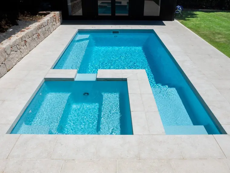 Coral Bay Series pool and spa in one piece beside a lawn
